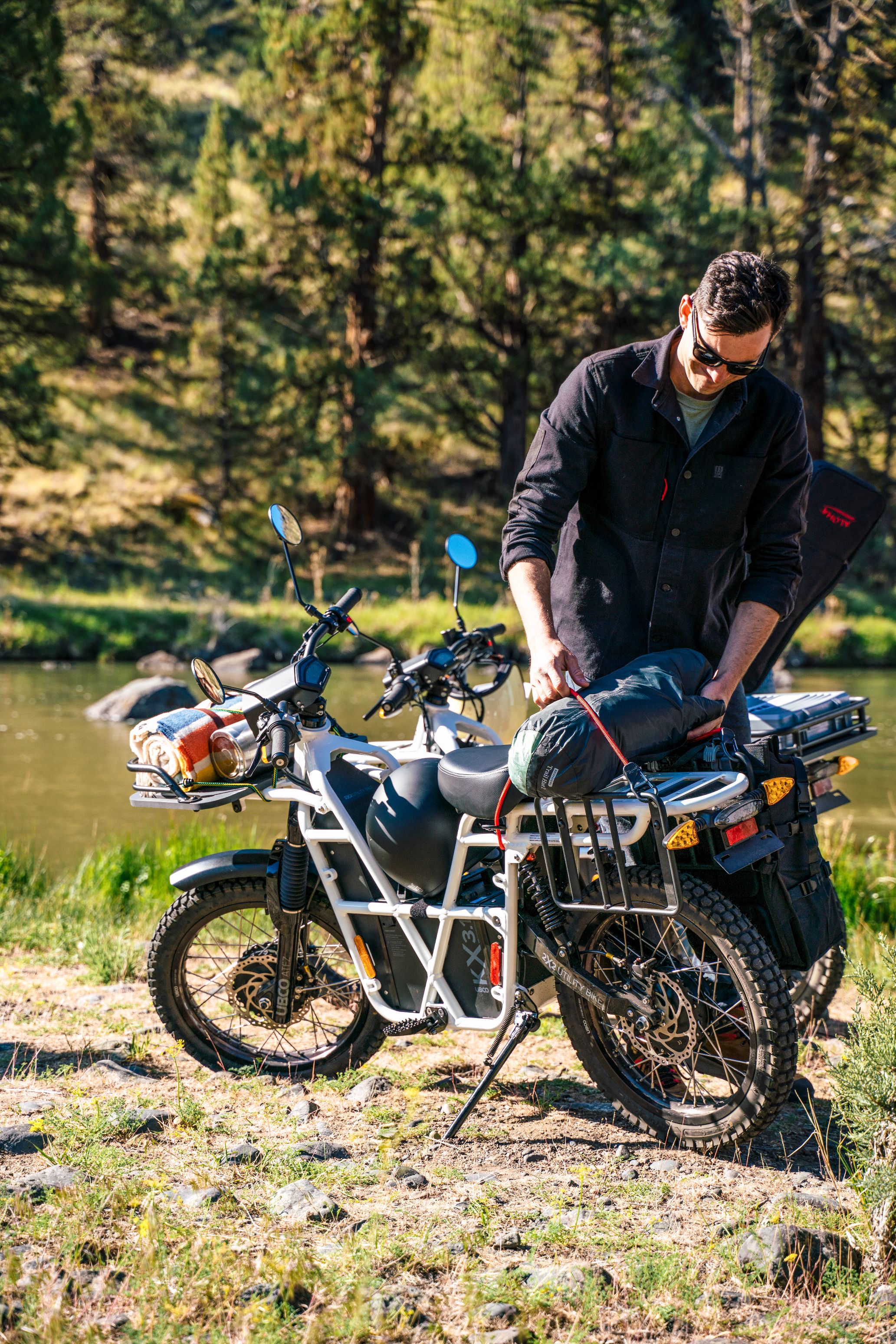 Explorateur devant un lac avec son véhicule éléctrique  UBCO